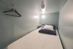 a small bedroom with a bed in the corner at E10 Hostel in Tokyo