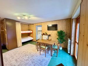 una camera con tavolo e una camera con letto di Accogliente appartamento a due minuti dal centro a Limone Piemonte