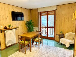una sala da pranzo con tavolo e sedie in legno di Accogliente appartamento a due minuti dal centro a Limone Piemonte