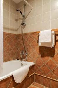 een badkamer met een douche en een wastafel met handdoeken bij Ca la Gloria in Vilabertrán
