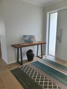 a room with a table with a laptop on it at Sand Castle in Whitianga