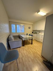 a living room with a table and chairs and a kitchen at Loft house Karihaara in Kemi