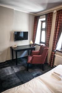 Televízia a/alebo spoločenská miestnosť v ubytovaní Apartamenty Siedem Komnat Siedmiu Mistrzów