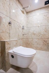 a bathroom with a white toilet and a shower at Hotel Crystal By Glitz Hotels in Mumbai