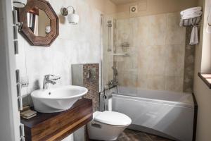 łazienka z umywalką, wanną i toaletą w obiekcie Apartamenty Siedem Komnat Siedmiu Mistrzów w Toruniu
