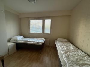 a small room with two beds and a window at Loft house Karihaara in Kemi