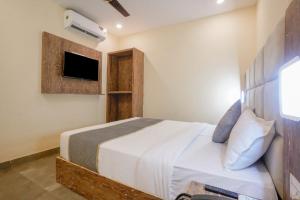 a bedroom with a bed and a tv on the wall at Hotel Crystal By Glitz Hotels in Mumbai
