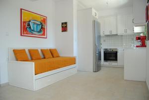 a bedroom with an orange bed and a kitchen at Villa Tati in Kastós