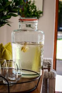 a glass jar filled with water on a table with glasses at Palm La Vie in Worcester