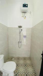 a bathroom with a toilet and a shower in it at Evara Hill Homestay in Uluwatu