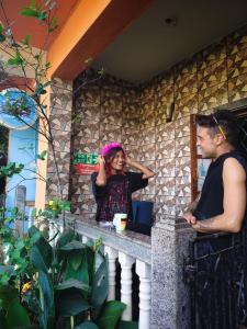 a man and a woman standing at a counter at Last Minute Trip Hostel Morjim-By The Sea in Morjim