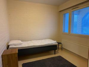 a small room with a bed and a window at Loft house Karihaara in Kemi