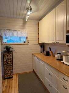a kitchen with white cabinets and a window at Kutala Cottage in Kutala