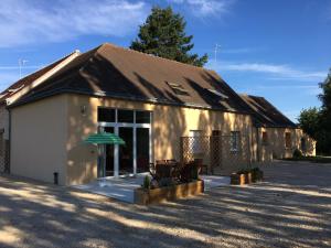 un edificio con una sombrilla verde delante de él en Le Domaine des Clairaies, en Artannes-sur-Indre