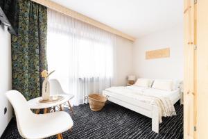 a white bedroom with a bed and a table at Willa Dunajec in Zakopane