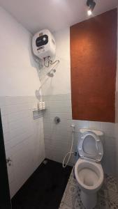 a bathroom with a toilet with a hair dryer on the wall at ŚamaStay in Yogyakarta