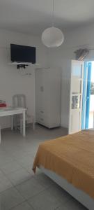 a bedroom with a bed and a tv on the wall at Filina's Studio Corner in Maltezana