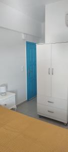 a room with a blue door and a white cabinet at Filina's Studio Corner in Maltezana