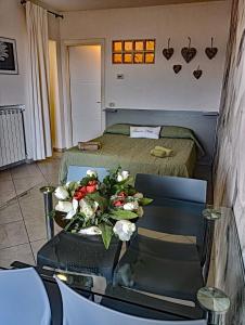 una stanza con un letto e un tavolo con dei fiori sopra di Monolocale Tre Mari a Capoliveri