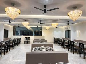 a dining room with tables and chairs and chandeliers at Hotel Rajwada Aurangabad in Aurangabad