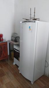 ein weißer Kühlschrank in einer Küche neben einem Herd in der Unterkunft Casa para alugar in Paraty