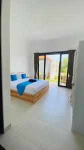 a bedroom with a bed and a large window at Evara Hill Homestay in Uluwatu