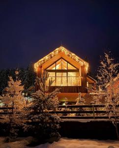 een gebouw bedekt met kerstverlichting in de sneeuw bij Chalet 4hills, Demänovská Dolina in Liptovský Mikuláš