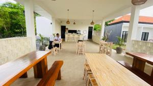 a person sitting at a table in a room with benches at Evara Hill Homestay in Uluwatu +14 photos