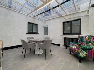 a conservatory with a table and chairs and a glass ceiling at Apartment in Omagh in Omagh +1 photo