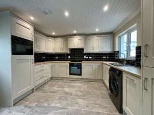 a kitchen with white cabinets and a dishwasher at Apartment in Omagh in Omagh