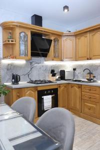 a kitchen with wooden cabinets and a stove top oven at Садиба "Hutsulyana" in Dobrovelychkivka