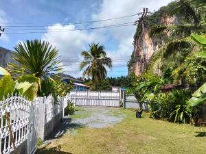 a house with a fence and a mountain in the background at Mountain View Garden House in Ban Chong Phli