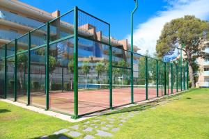 una pista de tenis frente a un edificio en UHC Spa Aqquaria Family Complex, en Salou