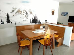 a dining room with a table with a bottle of wine at Appartamento Miele di Pino in Ziano di Fiemme +17 photos
