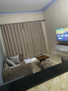 a living room with a couch and a flat screen tv at Merry in Kampala +6 photos