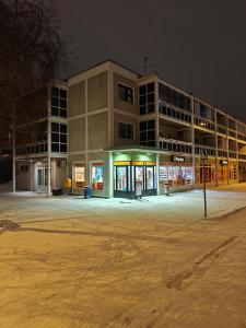 an empty parking lot in front of a building at night at Kaupunkikoti omalla saunalla sekä lähellä juna-asemaa, 100M Wifi in Järvenpää
