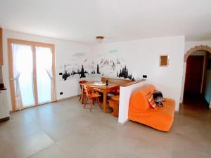 a dining room with an orange couch and a table at Appartamento Miele di Pino in Ziano di Fiemme