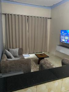 a living room with two couches and a flat screen tv at Merry in Kampala