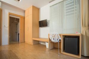 a room with a desk with a tv and a chair at Casa De Coral Boutique Hotel in Kata Beach