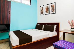 a bedroom with a bed and a blue wall at Hotel O Akash Namostay in Jamshedpur