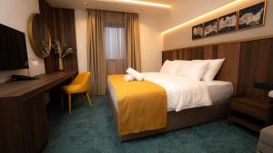 a hotel room with a large bed and a desk at Hotel Central in Inđija