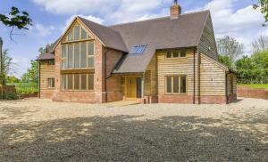 a house with a large driveway in front of it at Glebe Barn in Cuxham