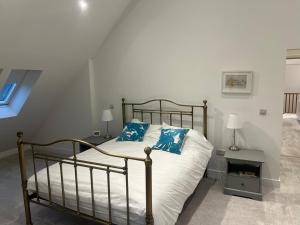 a bedroom with a bed with blue pillows on it at Glebe Barn in Cuxham