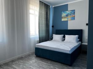 a bedroom with a bed with blue walls and a window at KRich Hotel Aktobe in Aktobe +18 photos