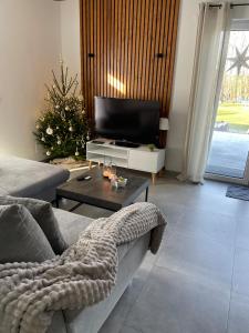 a living room with a couch and a television at Ferienwohnung in der wunderschönen Eifel in Dankerath