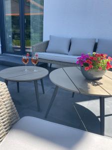 a patio with two tables and a couch and flowers at Ferienwohnung in der wunderschönen Eifel in Dankerath
