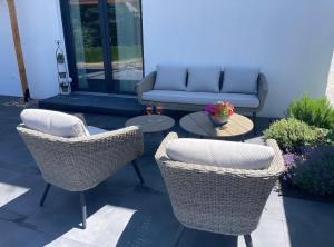a patio with chairs and a couch and a table at Ferienwohnung in der wunderschönen Eifel in Dankerath
