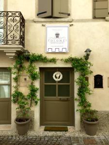 uma porta verde ao lado de um edifício com plantas em Residenza Dei Tolomei Polcenigo em Polcenigo