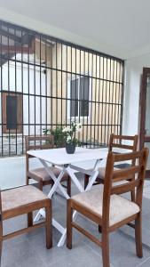een witte tafel en twee stoelen en een tafel en een raam bij Sunray Homes in Disagewatta