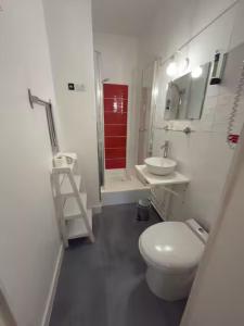a white bathroom with a toilet and a sink at Aux Vendanges de Bourgogne in Paray-le-Monial